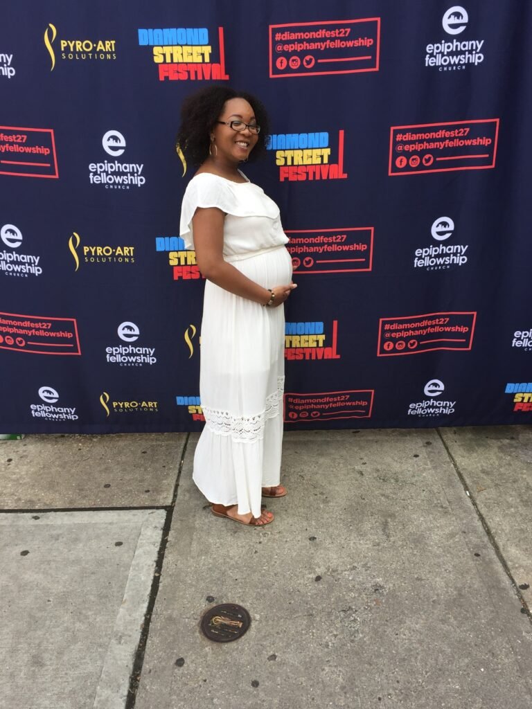 woman holding pregnant belly outside. voice loss